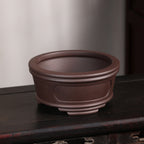 Angled view of brown round pot showing open interior and double rim