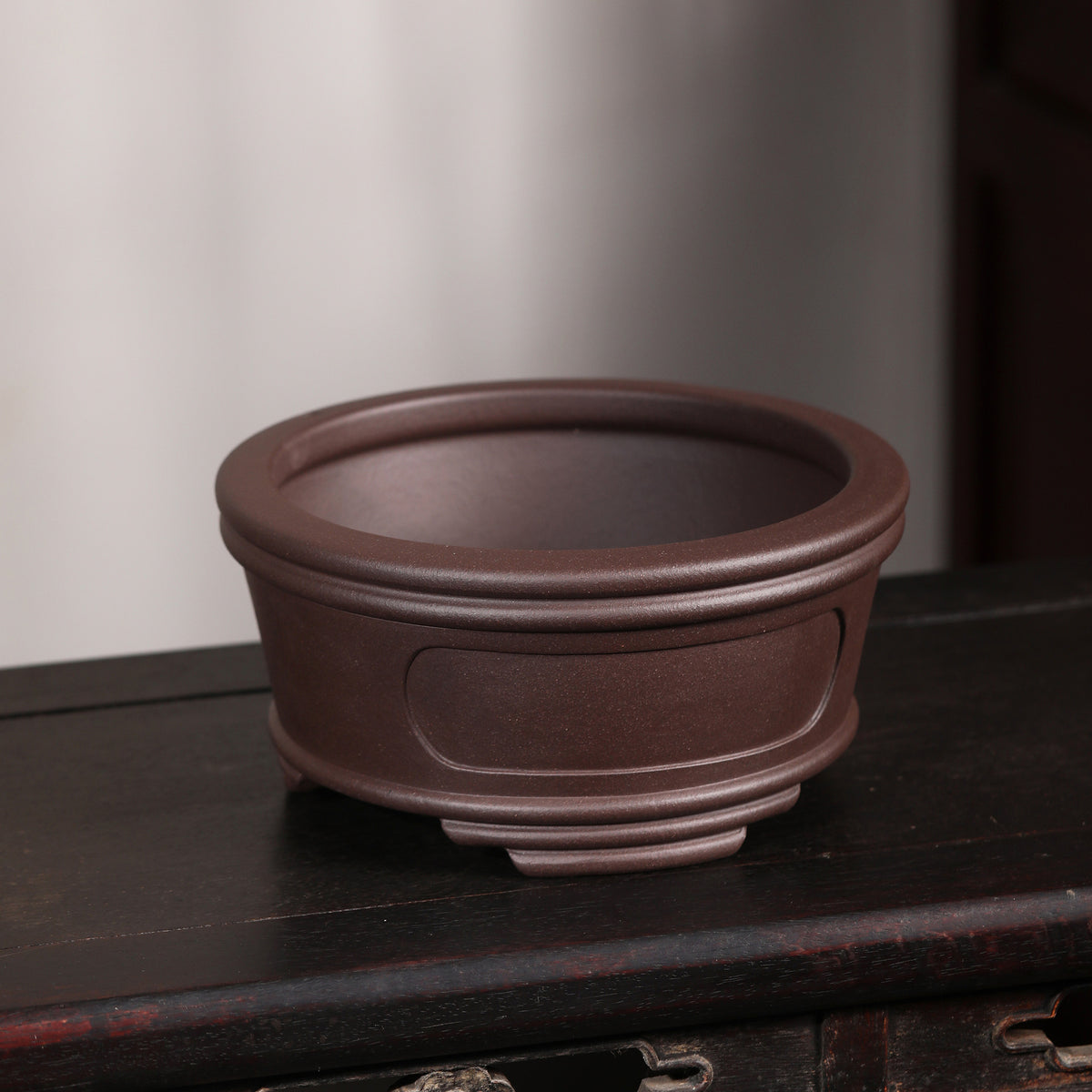 Angled view of brown round pot showing open interior and double rim