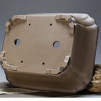 Underside of taupe rectangular pot with two large openings and four small holes