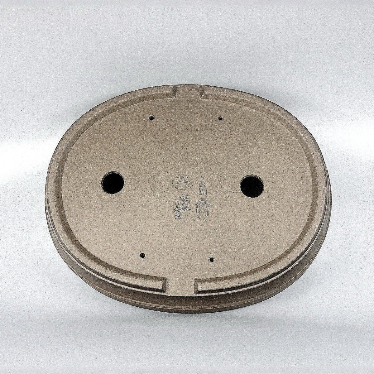 Underside of the taupe oval pot with two drainage holes