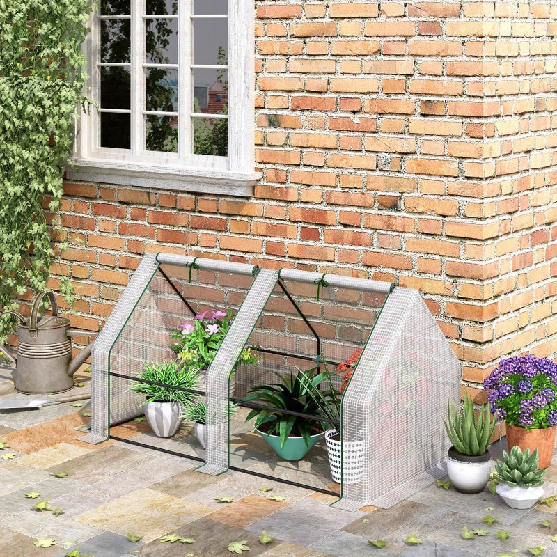 White PE mini greenhouse beside outdoor potted plants