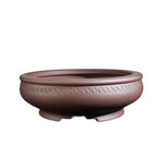 Isolated round brown pot with coin-like ornament band
