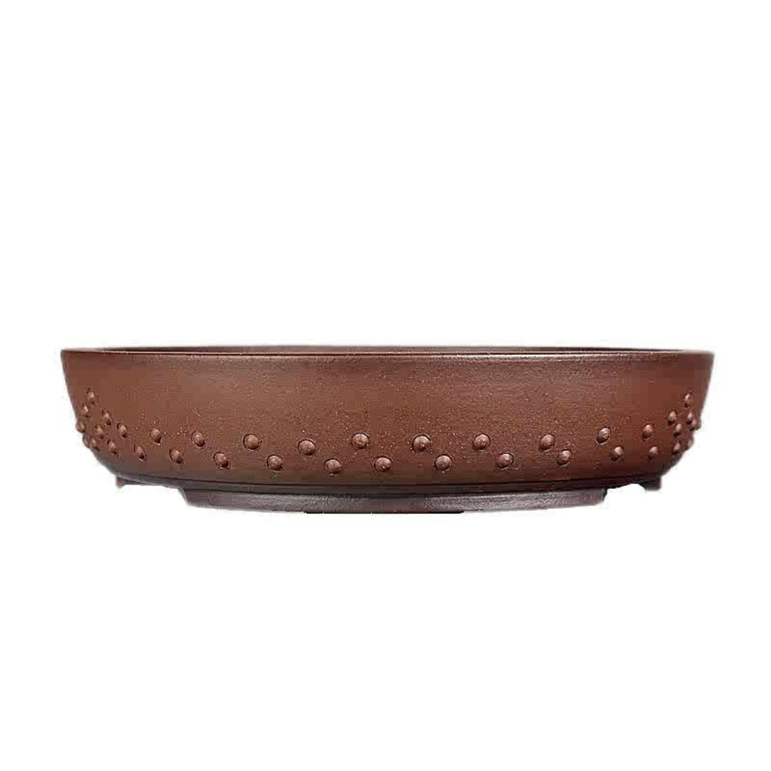 Side profile of the shallow brown round pot with raised studs