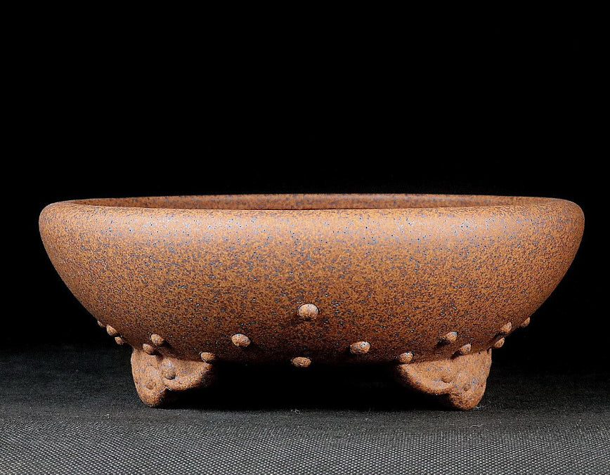 Side view of the brown studded pot with cloud-like feet