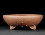 Side view of the brown studded pot with cloud-like feet