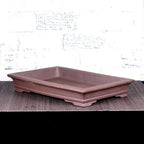 Brown rectangular bonsai pot with flared rim and low feet, angled view