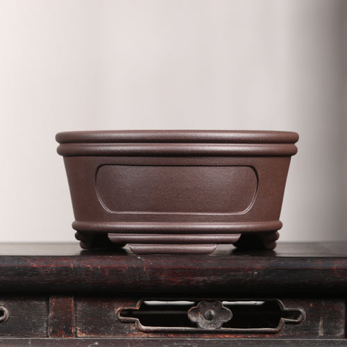Brown round bonsai pot with recessed oval panels, double rim and raised feet