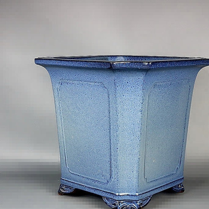 Angled view of the tall blue pot's flared rim and speckled glaze