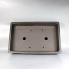 Interior of the rectangular bonsai pot showing two drainage holes and four tie-down openings