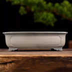 Taupe rectangular bonsai pot with framed side panel and decorative feet