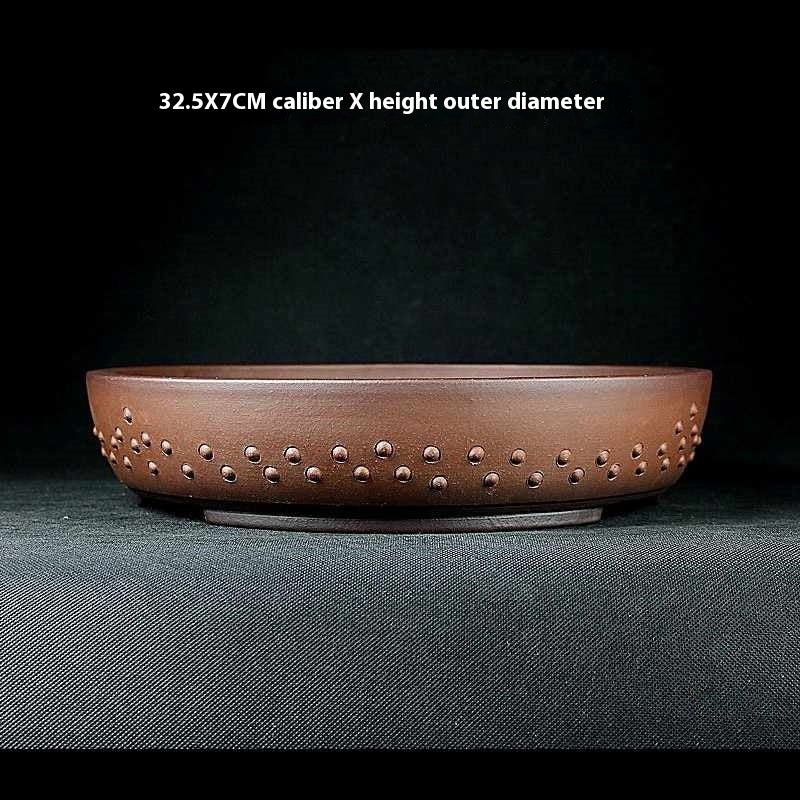 Studded reddish-brown round pot with a printed 32.5 by 7 cm size label
