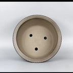 Top view of taupe round bonsai pot showing three drainage openings
