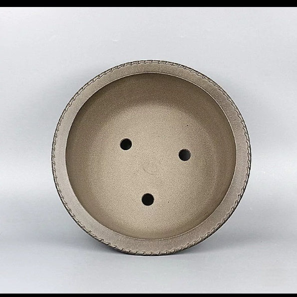 Top view of taupe round bonsai pot showing three drainage openings