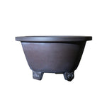 Isolated dark brown round pot with flared rim and decorative feet