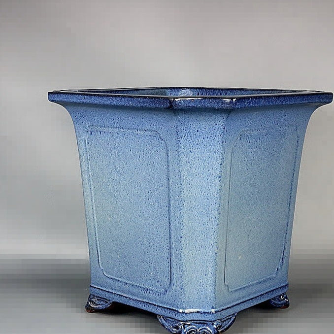 Three-quarter view showing the blue pot's beveled corners and paneled sides