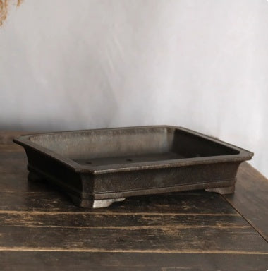Angled dark rectangular pot showing open interior and banded base