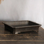 Angled dark rectangular pot showing open interior and banded base