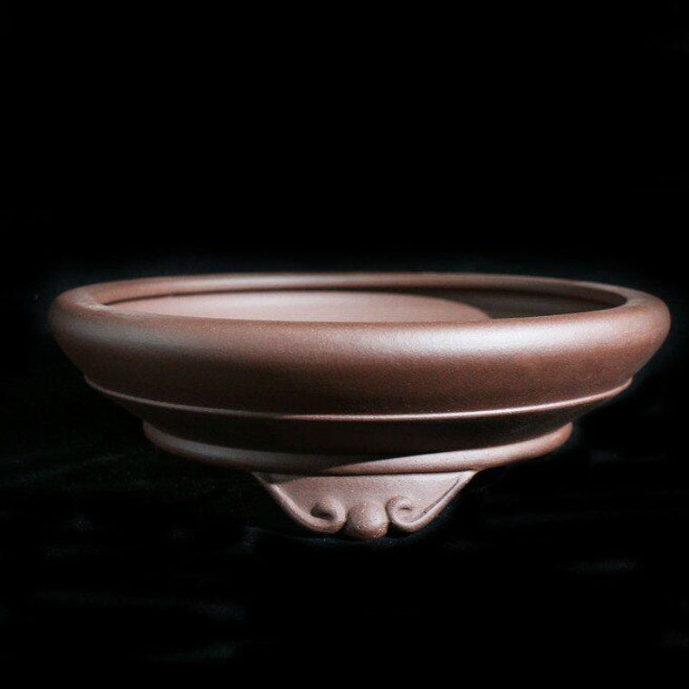 Cloud-foot detail and rolled rim of round Zisha pot