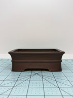 Long-side view of the dark brown rectangular pot with flared rim and low feet