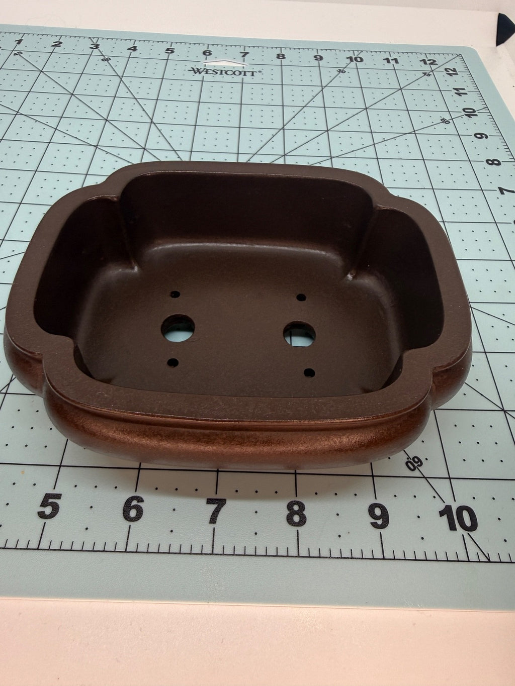 Top view of the brown mokko pot showing its lobed opening and two drainage holes