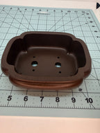Top view of the brown mokko pot showing its lobed opening and two drainage holes