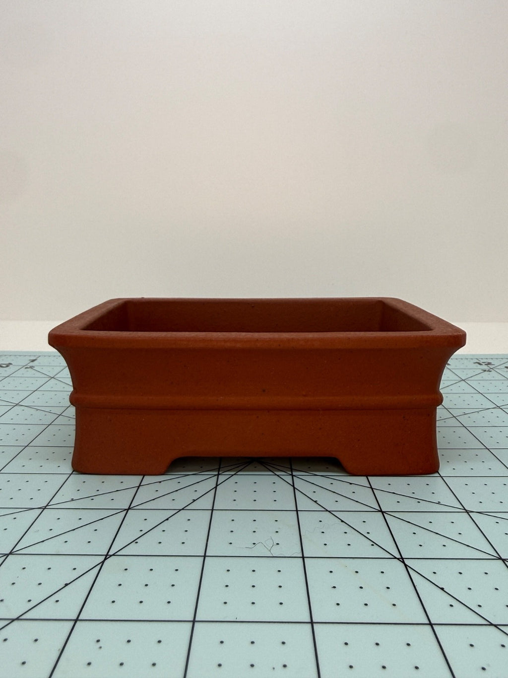 Low front view of the red rectangular pot showing its raised horizontal band