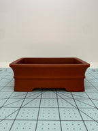 Low front view of the red rectangular pot showing its raised horizontal band