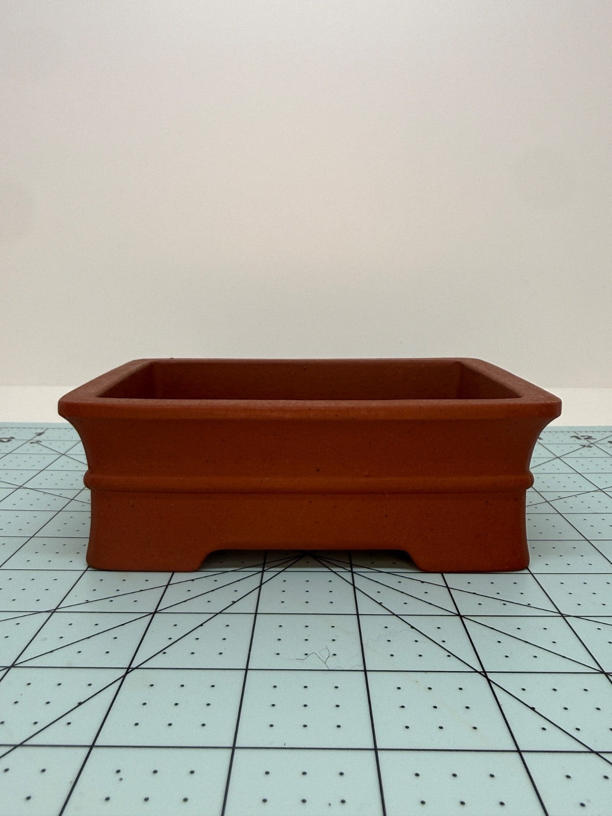Low front view of the red rectangular pot showing its raised horizontal band