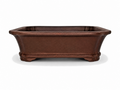 Brown rectangular bonsai pot with flared rim, tapered walls and shaped feet