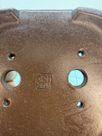 Close-up of an impressed square seal and drainage openings on the mokko pot's base