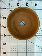 Overhead interior view of the ochre pot with one central drainage hole on a measuring grid