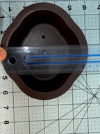 Ruler across the width of the brown oval pot's interior