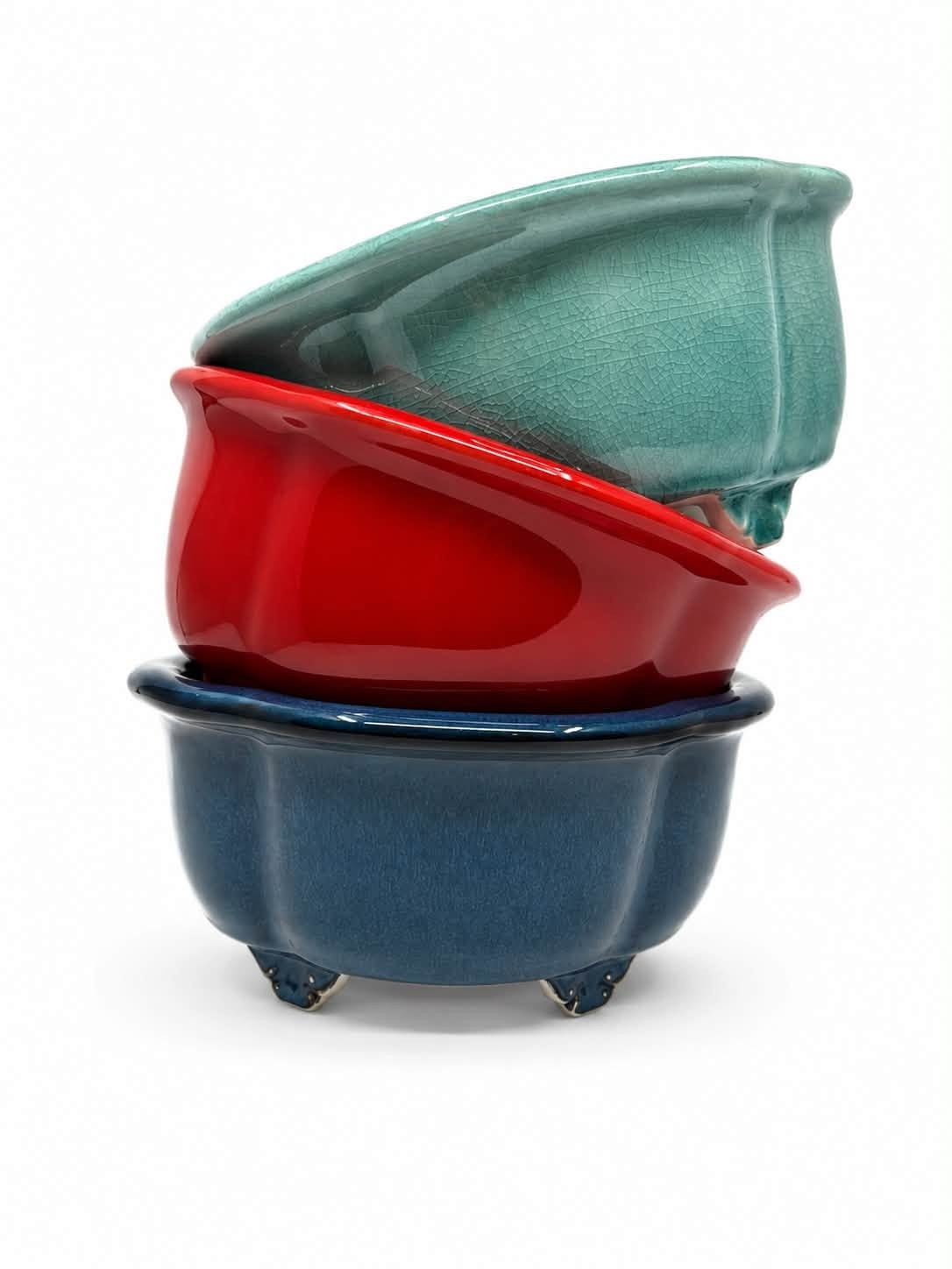 Three lobed oval bonsai pots stacked in turquoise, red and dark blue glazes