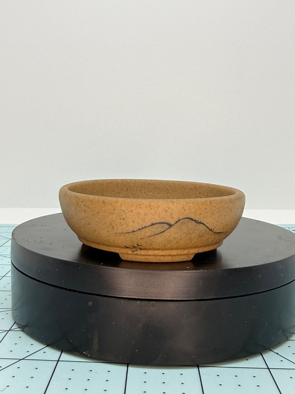Front view of the ochre oval pot with mountain-line decoration