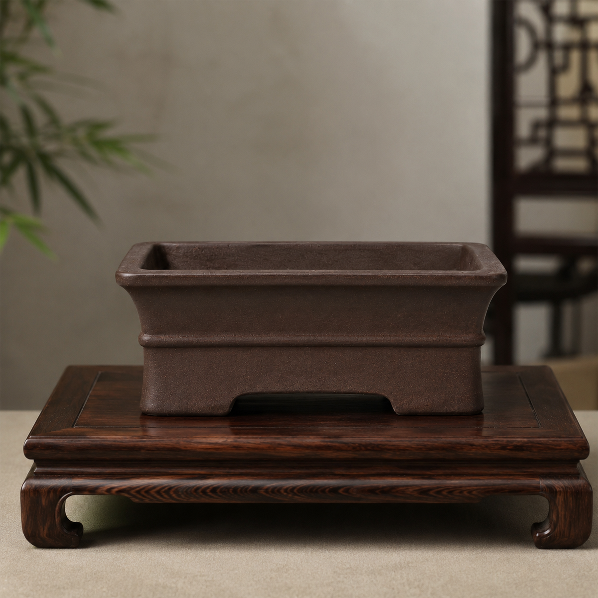 Dark brown rectangular bonsai pot displayed on a carved wooden stand