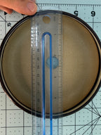 Ruler across the round pot's pale interior opening