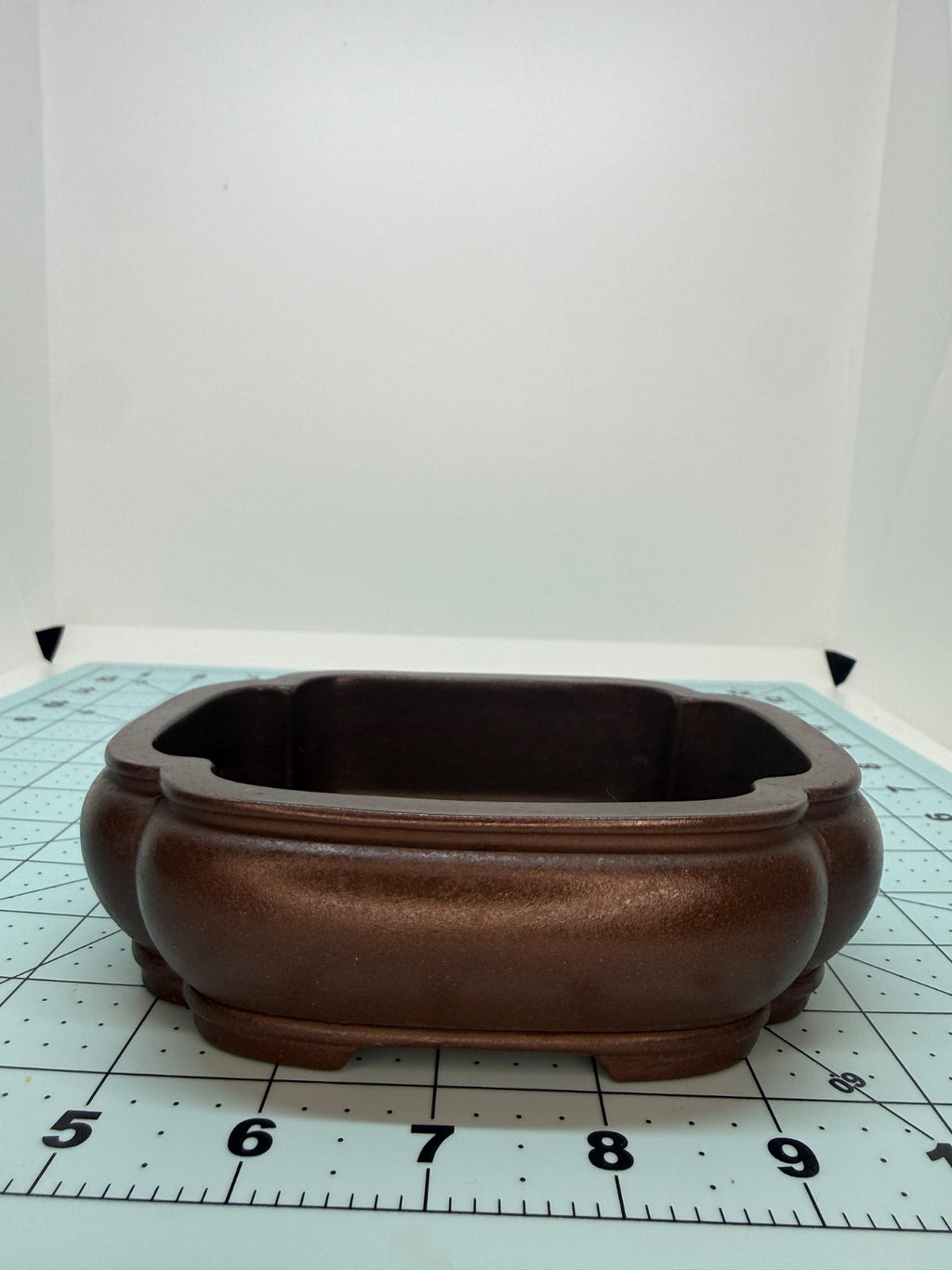Long-side view of the brown mokko pot showing its rounded walls and layered rim