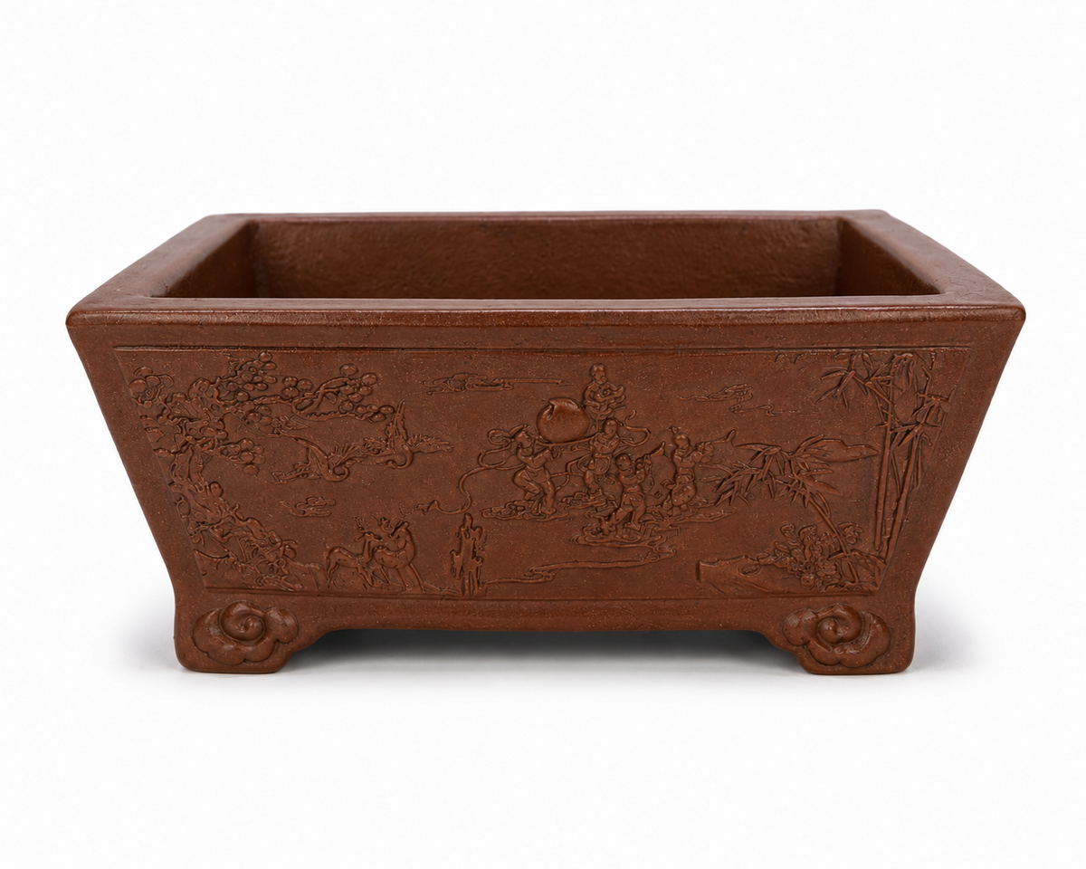 Reddish-brown rectangular bonsai pot with landscape relief, tapered walls and curled feet