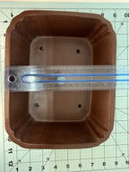 Ruler spanning the width of the brown rectangular pot's interior