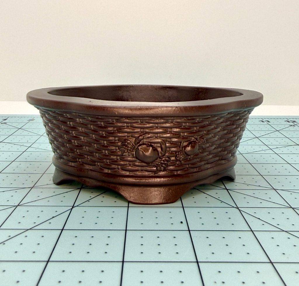 Front view of the brown basket-weave pot showing a raised ring ornament