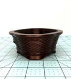 Angled end view of the brown oval pot's woven texture and low feet