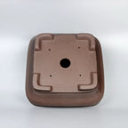 Underside of the brown square pot with central drainage and small holes