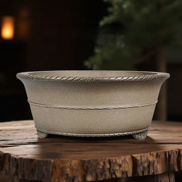 Taupe round bonsai pot with rope-pattern rim and decorative feet on a stump