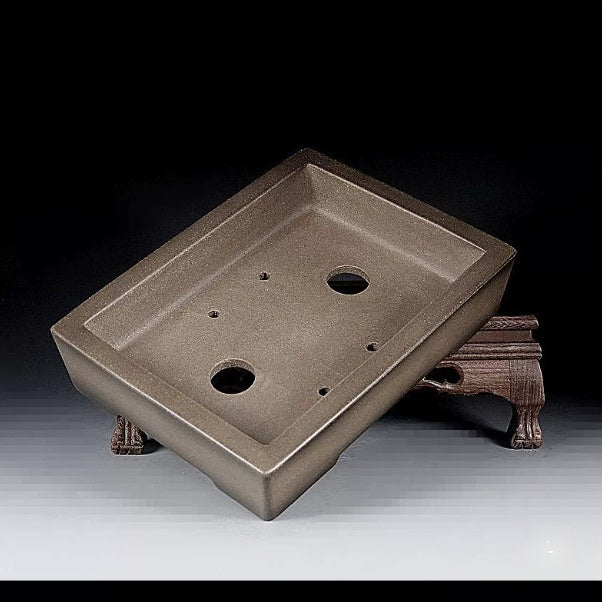 Angled interior of taupe rectangular pot showing drainage openings