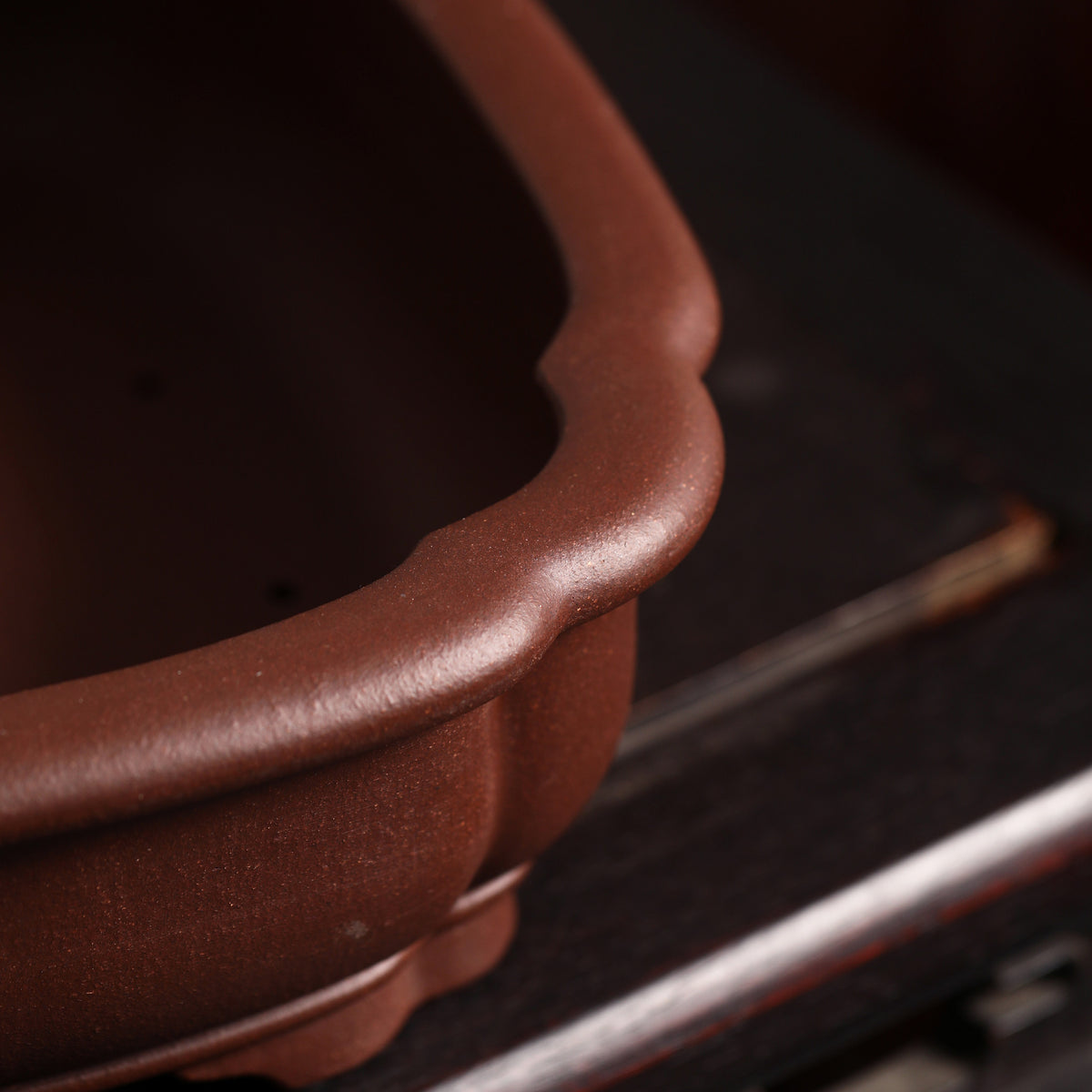 Curved corner and rim detail of brown mokko bonsai pot
