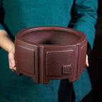 Deep brown hexagonal Zisha bonsai pot, held to show scale