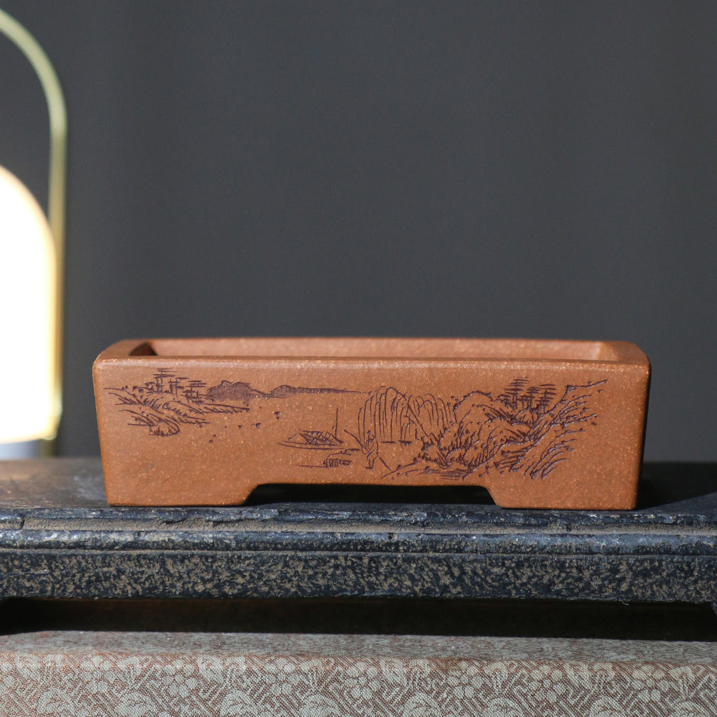 Red-brown rectangular pot with landscape decoration on a stand