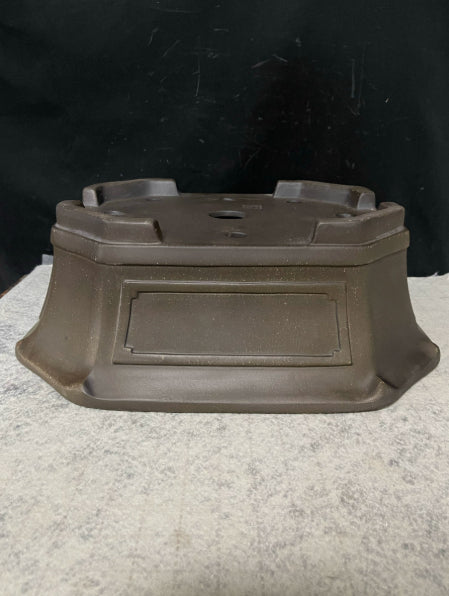 Upside-down dark brown clipped-corner pot showing base and feet