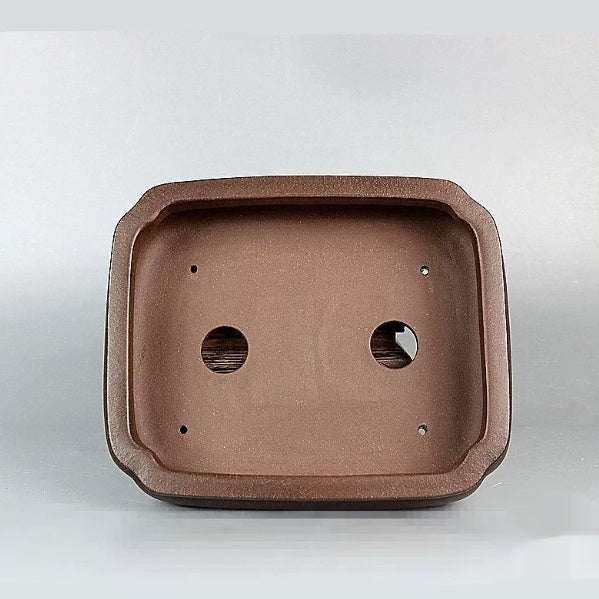 Interior of the brown rectangular pot with two drainage holes and four smaller openings