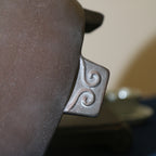 Close-up of a curled relief foot on the dark brown pot